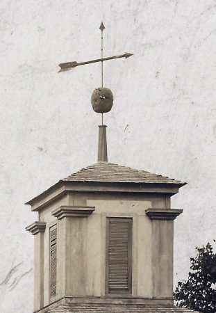 Magnified view of the Universalist Church Cupola and weathervane  from the old 1870’s photo of Main Street. Notice the bullet holes in the decorative ball and holes in the feathers on the arrow. Stories in the old Troy Free Press talk about Union soldiers during the occupation of Troy in the Civil War would use it for target practice, firing at it from the blockhouse fortification across the street. This photo gives evidence to the story. In addition Civil War era Minie bullets and lead pistol balls have been found in that area where the blockhouse fort was located. 
The cupola is long gone off the building, but the building is still standing and part of Hechler Hardware.